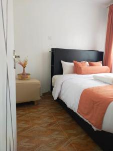 a bedroom with two beds with orange and white pillows at Bloom private home in Thika