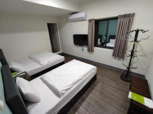 Habitación hospitalaria con 2 camas y ventana en 莒光英雄館民宿 B&b en Juguang