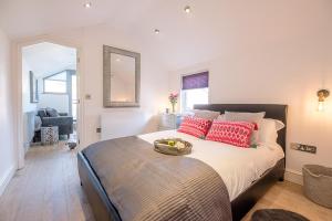 a bedroom with a bed with a bowl of fruit on it at Papillon Southwold - A Modern Flat with Balcony in Southwold