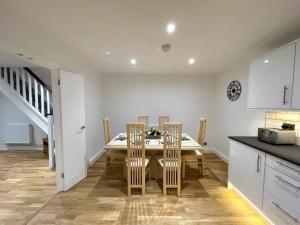 a kitchen and dining room with a table and chairs at Yr Hen Bopty (The Old Bakery) in Pontypridd