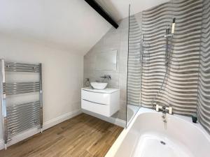 a bathroom with a sink and a bath tub at Yr Hen Bopty (The Old Bakery) in Pontypridd +8 photos