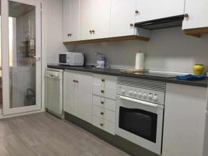 a kitchen with white cabinets and a stove top oven at Las Mimvas centro excellent in Castellón de la Plana