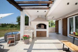 an outdoor patio with a fireplace and a bench at Villa Irena in Medulin