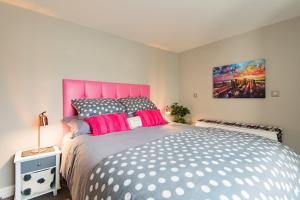 een slaapkamer met een groot bed met een roze hoofdeinde bij Pier View - beautiful sea view apartment in Deal in Kent