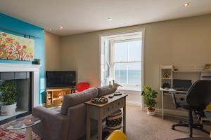een woonkamer met een bank en een open haard bij Pier View - beautiful sea view apartment in Deal in Kent