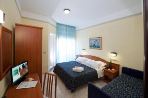 a hotel room with a bed and a table at Hotel Queen Mary in Cattolica