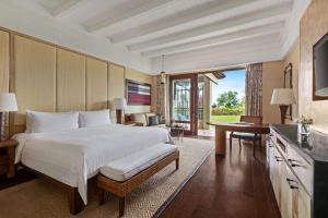 a bedroom with a large bed and a desk and a table at Shangri-La Boracay in Boracay