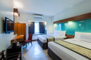 A bed or beds in a room at Microtel by Wyndham UP Technohub