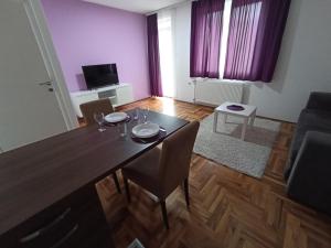 a dining table and chairs in a living room at Sunny apartment in Niš