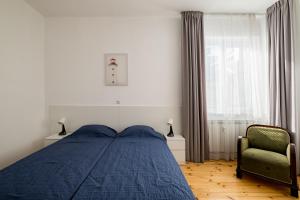 a bedroom with a bed and a chair and a window at Spacious 3 Bedroom Home in Sofia's Top Center in Sofia