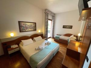 a hotel room with two beds and a window at Hotel Meridiana in Sirmione