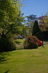 a park with flowers and a light pole in the grass at Pendragon Country House in Camelford