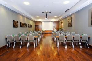 a room with rows of chairs and a white screen at Hotel NH Poznan in Poznań