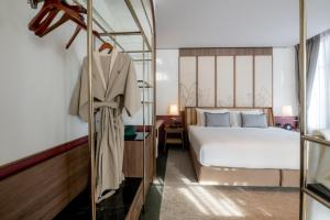 a hotel room with a bed and a mirror at Hotel MOCO in Udon Thani