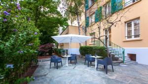 日內瓦的住宿－Geneva By Fassbind，一个带桌椅和遮阳伞的庭院