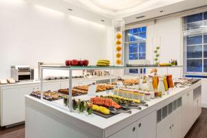 a kitchen filled with lots of different types of food at NH London Kensington in London