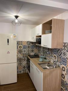 eine kleine Küche mit Spüle und Kühlschrank in der Unterkunft Silvi's House in Neapel