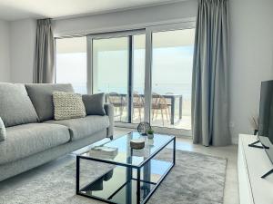 salon z kanapą i szklanym stołem w obiekcie Via Celere 2330 Sea View Apartment w mieście Casares