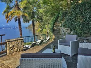 a patio with two chairs and a table with a bottle of wine at Gioconda Villa in Varenna