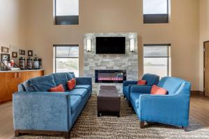 a living room with two blue couches and a fireplace at Comfort Inn Hamburg Area I-75 Lexington in Lexington