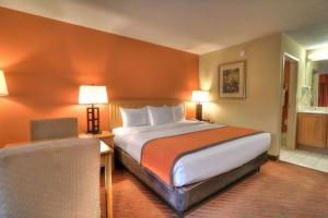 Una habitación de hotel con una cama grande y una silla. en Econo Lodge Pigeon Forge Riverside, en Pigeon Forge 37 fotos más