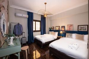 ein Schlafzimmer mit 2 Betten und einer Kommode darin in der Unterkunft The Bold Parisian House - Steps From The Best Mall in Cairo in Kairo