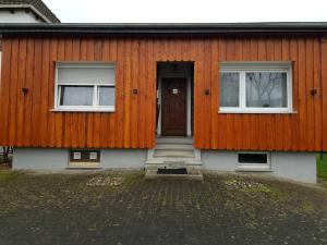 una casa con una pared de color naranja y una puerta en Unterkunft Iseringhausen, en Drolshagen