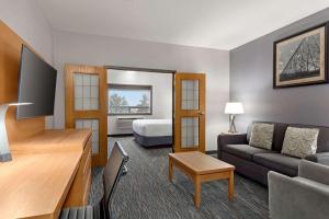 a living room with a couch and a bed in a room at Wingate by Wyndham Lethbridge in Lethbridge