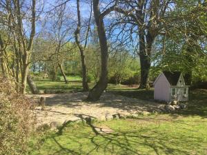 a small house in the middle of a field with trees at Ferienhaus 1 _ Ferien im Gutspark in Mattchow