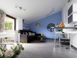 a living room with blue walls and a black couch at Matarolux23 in Mataró