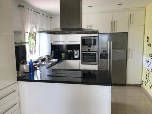 a kitchen with black counter tops and stainless steel appliances at Villa Sol in Callao Salvaje