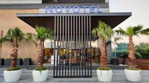 un hôtel avec des palmiers devant un bâtiment dans l'établissement Novotel Chandigarh Tribune Chowk, à Chandigarh