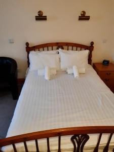 a bed with white sheets and pillows at The Old Colliery Stables in Durham