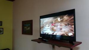 telewizor z płaskim ekranem na drewnianej półce w obiekcie Стаи за гости ОРЕХА Троян Private rooms Oreha w Trojanie