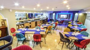 a restaurant with tables and chairs and a kitchen at MARİNA HOTEL in Izmir