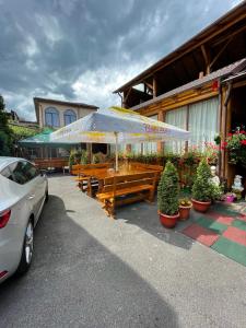 a restaurant with tables and umbrellas in front of a building at Pensiunea Nico Pardon in Cîmpulung