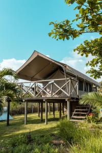 ein großes Gebäude mit einem Dach auf dem Rasen in der Unterkunft Otentic, Eco Tent Experience in Grande Rivière Sud Est