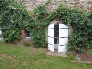 une porte blanche sur le côté d'un bâtiment en briques dans l'établissement Relais des Chaux, à Saint-Jean-des-Ollières