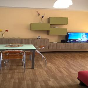 a living room with a table and a tv at Casa Vacanze A Pennichella in Canicattini Bagni