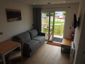 uma sala de estar com um sofá e uma mesa em The Cabins - House of Juniper em Broadford