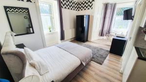 a bedroom with a large bed and a television in it at Bemersyde Villa-Studios in Mansewood