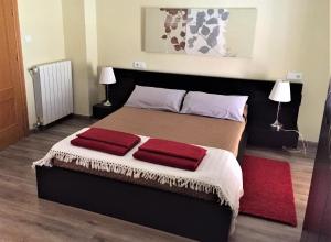 a bedroom with a bed with two red pillows on it at La Xaquera in Busot