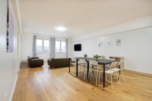 een woonkamer met een tafel en stoelen en een bank bij RAJ Living - 250m2 Loft with 6 Rooms im Industriegebiet - 20 Min Messe DUS & Old Town DUS in Düsseldorf