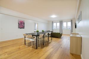 uma sala de jantar com mesa e cadeiras em RAJ Living - 250m2 Loft with 6 Rooms im Industriegebiet - 20 Min Messe DUS & Old Town DUS em Düsseldorf