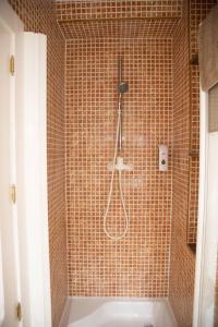 a shower with a shower head in a bathroom at RAJABAi in Almansa