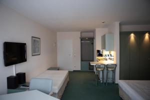 a hotel room with two beds and a kitchen at pepb Schulungshotel in Sarstedt