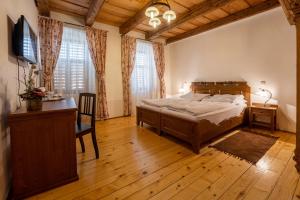 een slaapkamer met een bed, een bureau en een televisie bij Casa Kroner in Sighişoara