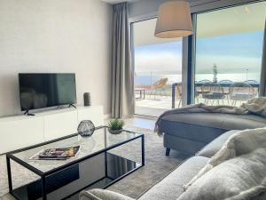 un soggiorno con un divano, una TV e un tavolo di Via Celere 2331 Luxury Sea View Apartment a Bahia de Casares