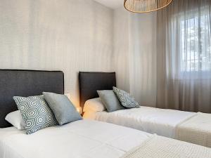 una camera da letto con due letti e un lampadario di Via Celere 2331 Luxury Sea View Apartment a Bahia de Casares Altre 19 foto