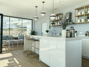 una cucina con mobili bianchi e un soggiorno di Via Celere 2331 Luxury Sea View Apartment a Bahia de Casares